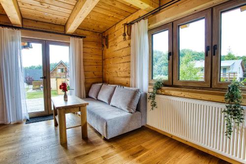 a living room with a couch and a table and windows at Agro Solina in Solina