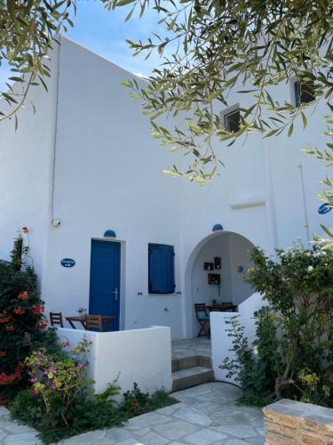 a white building with blue doors and some plants at Villa Gelly's Studios in Aliki
