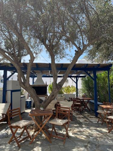 a group of tables and chairs under a tree at Villa Gelly's Studios in Aliki