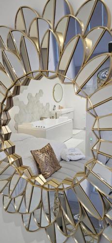 - un miroir en or dans une chambre avec un lit dans l'établissement Douceur Dorée, à Yville-sur-Seine
