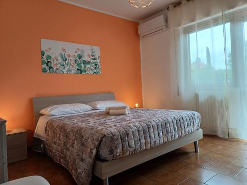 a bedroom with a bed with an orange wall at A casa di Ester appartamento in Passo Corese