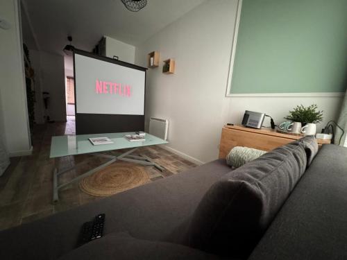 GambaisにあるLE NID - Charmante petite maison avec balnéoのリビングルーム(ソファ、プロジェクションスクリーン付)