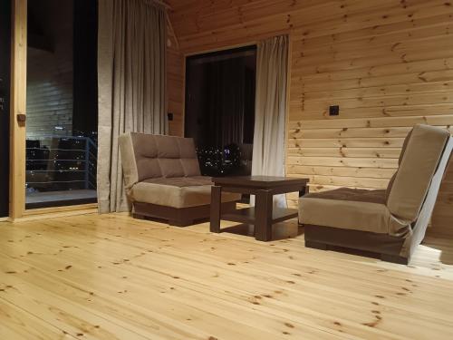 a living room with two chairs and a table at My house in Stepantsminda