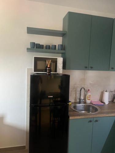 a kitchen with a microwave on top of a refrigerator at Апартман Ђокић in Banja Koviljača