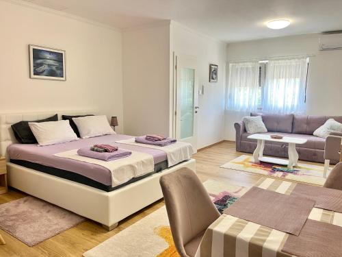 une chambre avec un grand lit et un canapé dans l'établissement Studio Rio, à Trebinje