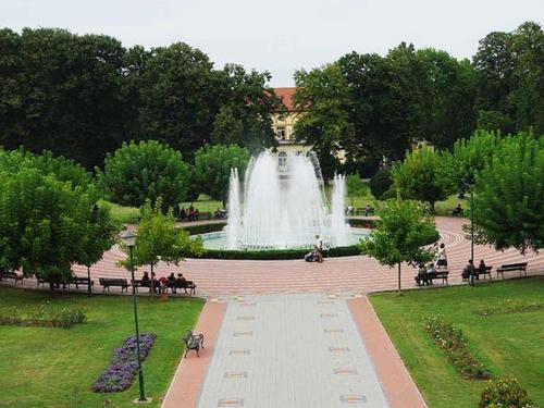 a fountain in the middle of a park with benches at Апартман Ђокић in Banja Koviljača