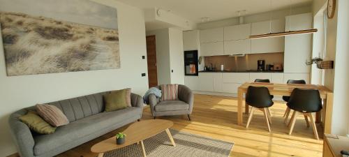 a living room with a couch and a table at Rannaäärne modernne korter uues majas in Pärnu