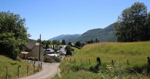 a dirt road in a village with mountains in the background at Lapuyade in Sainte-Colome