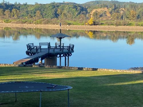 une table avec des bancs au bord d'un lac dans l'établissement Costa del Sol de Rapel, à La Estrella