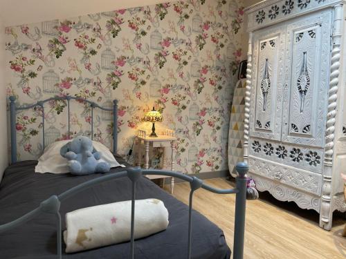 a bedroom with a bed in a room with floral wallpaper at Ene chocoa in Louhossoa