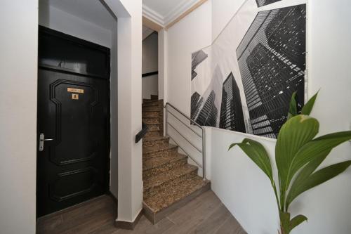 a hallway with a black door and a plant at OFOO Zagreb in Zagreb