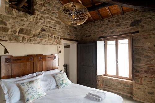a bedroom with a bed in a stone wall at Lìelà - Ospitalità di borgata in Roccavignale
