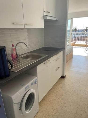 une cuisine avec un évier et une machine à laver dans l'établissement Magnifique studio avec vue - 200 metres de la plage, à Saint Cyprien Plage