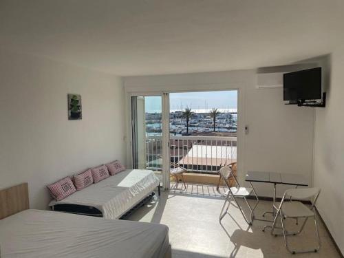 Cette chambre comprend deux lits et un balcon avec une télévision. dans l'établissement Magnifique studio avec vue - 200 metres de la plage, à Saint Cyprien Plage