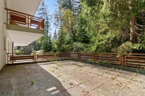a porch of a house with a wooden fence at Magnifique appartement avec piscine in Crans-Montana
