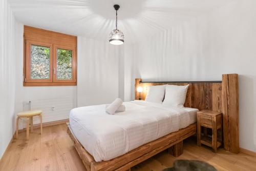 a bedroom with a large bed with white sheets at Magnifique appartement avec piscine in Crans-Montana