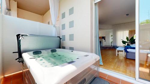 une baignoire dans une pièce avec une grande fenêtre dans l'établissement expat renting - L'eSPAce d'un Moment - Love room, à Toulouse