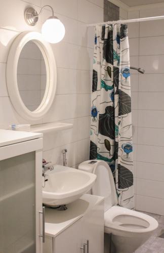 a bathroom with a sink toilet and a shower curtain at Poutapilvi in Bollstad