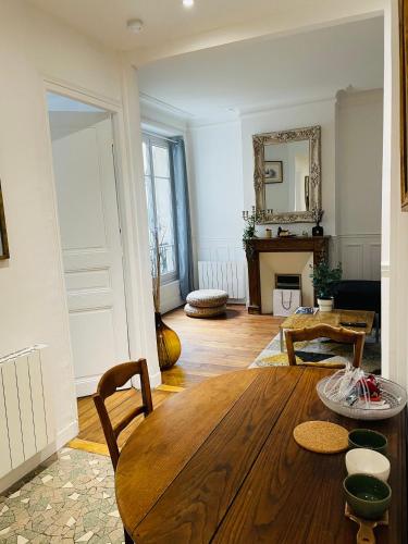 - un salon avec une table en bois et une cheminée dans l'établissement Charmant 2 pièces aux portes de Paris, à Levallois-Perret