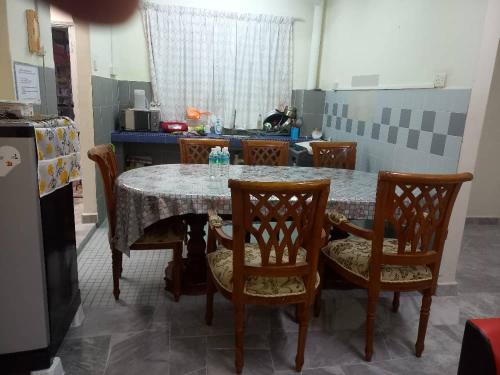 a kitchen with a table with chairs and a table and a kitchen at PD BATU 9 Cocobay Resort Condominium in Kampong Tanah Merah