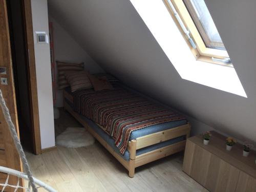 a bedroom with a bed in a attic at Domek Zielona Sowa in Siemianówka