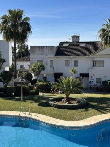 a swimming pool in front of a large building at Chalet con barbacoa y piscina in Estepona