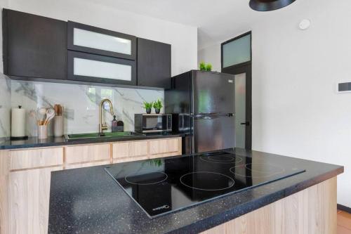 a kitchen with black counter tops and a stainless steel refrigerator at Casa Serenidad en las Montañas in Orocovis
