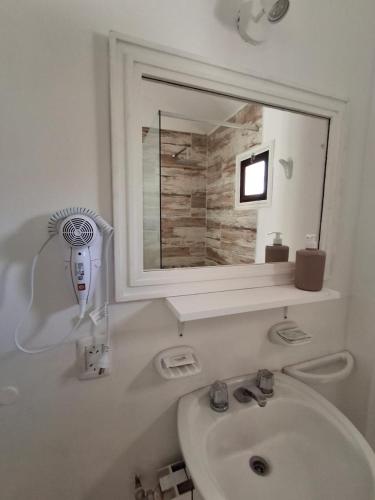 a white bathroom with a sink and a mirror at Los Tarcos Guest House in San Salvador de Jujuy