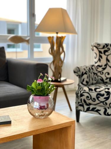 a living room with a table with a vase with a plant in it at Goldsprotte in Eckernförde
