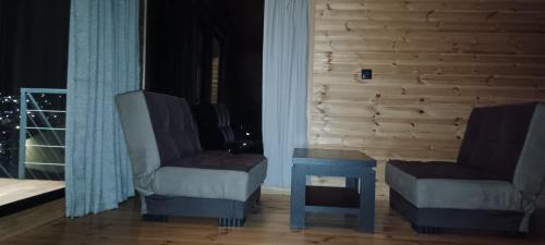 a living room with two chairs and a table at My house in Stepantsminda
