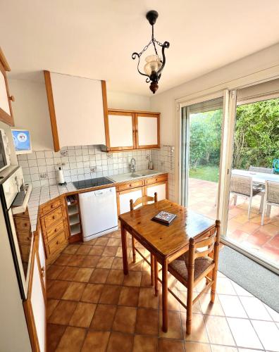 une cuisine avec une table en bois et une table dans l'établissement Maison Provençale avec Jacuzzi, à LʼIsle-sur-la-Sorgue