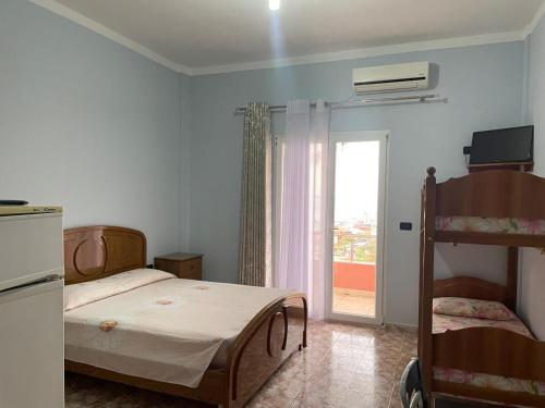 a bedroom with a bunk bed and a balcony at Vila Frroku in Shëngjin
