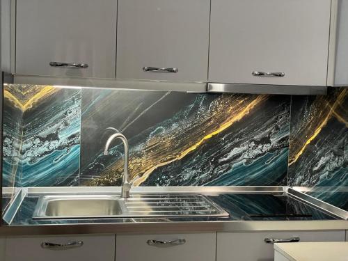 a kitchen with white cabinets and a sink at Vila Frroku in Shëngjin