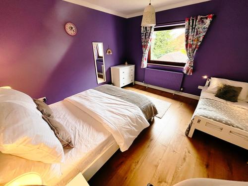 a bedroom with purple walls and a bed and a window at Gorgeous Family 3 Bedroom Home in Newbury