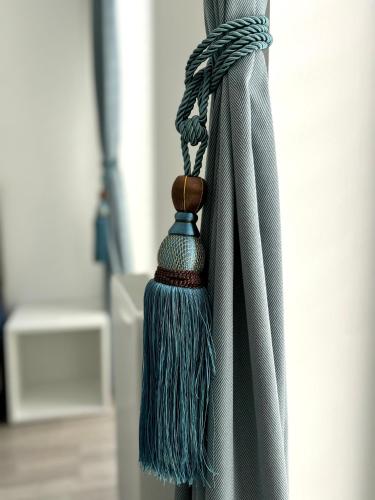 a close up of a curtain with a blue tassel at Jezerní apartmán s terasou a saunou v Lakepark Residence in Doksy
