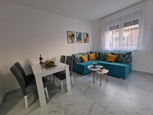 a living room with a blue couch and a table at Apartman Anđela&Aleksa in Banja Koviljača