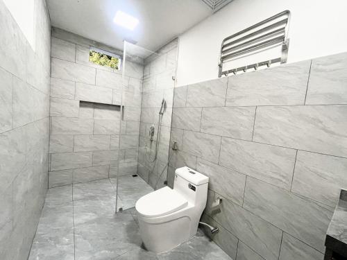 a white bathroom with a toilet and a shower at La Palma Suites in Ukulhas
