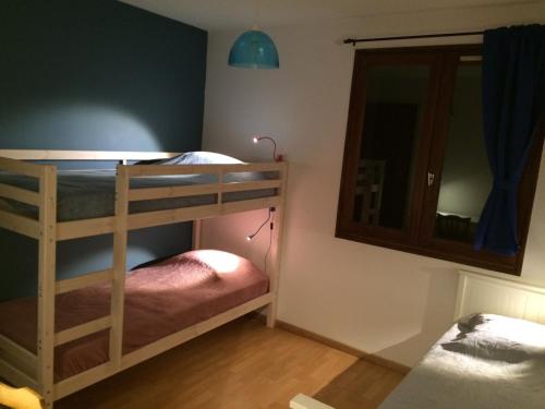 a bedroom with two bunk beds and a mirror at T3 avec terrasse plein sud au pied des télécabines in Briançon