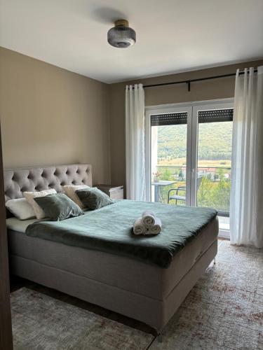 a bedroom with a large bed with a large window at Villa Panorama Rakitno in Posušje