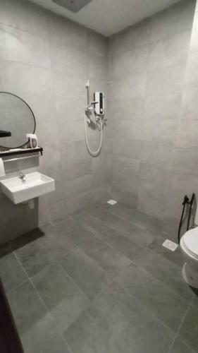 a bathroom with a shower and a sink and a toilet at Yumi Staycation 3R2B, Doncaster Residence in Maong Bazaar