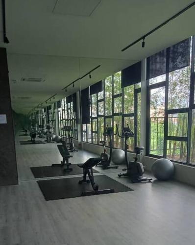 a gym with a lot of pilates equipment and windows at Yumi Staycation 3R2B, Doncaster Residence in Maong Bazaar