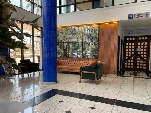 a lobby with a bench in a building at Panorama Tower Hotel in Ipatinga