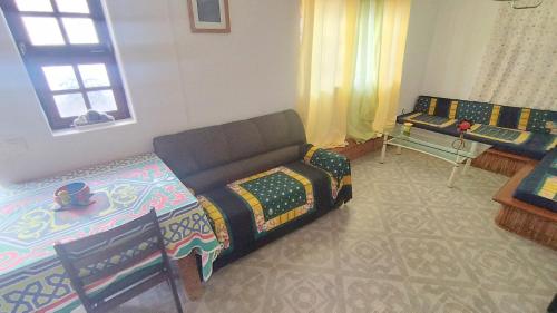 a living room with a couch and a table at Pensão Alcinda Bettencourt 100 meters to the Beachfront in Santa Maria