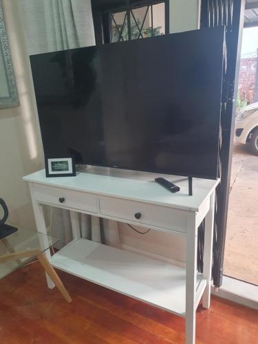 a white desk with a large tv on top of it at One Three Nine On Roberts in Pietermaritzburg