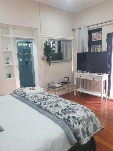 a bedroom with a bed and a flat screen tv at One Three Nine On Roberts in Pietermaritzburg