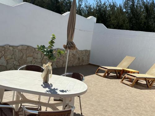 a patio with a table and chairs and an umbrella at Casa Adriana in Costa Calma