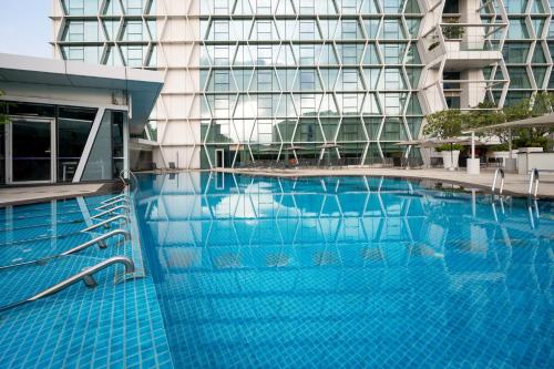 a large blue swimming pool in a building at Dorsett Changi City Singapore in Singapore