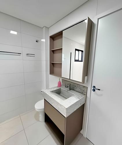 a bathroom with a sink and a toilet at Studio com ar-condicionado no Centro! in Guarapuava