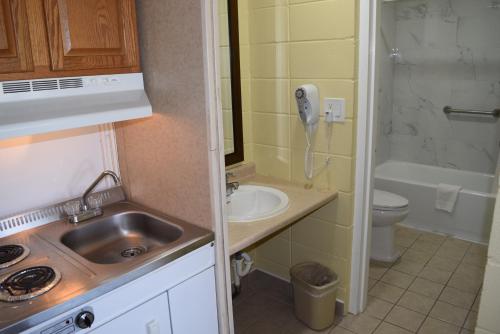 a small bathroom with a sink and a phone at White Oaks Motel Pennsville/Carneys Point in Pennsville