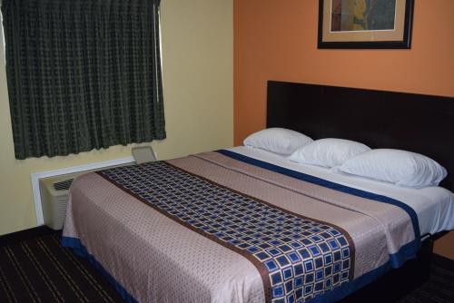 a hotel room with a bed with two pillows at White Oaks Motel Pennsville/Carneys Point in Pennsville